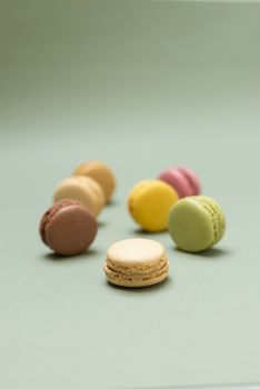 Colored tasty  macaroons over a green background.