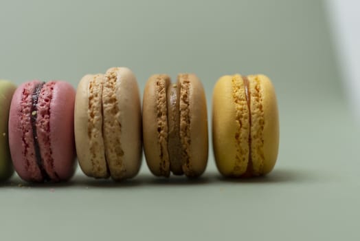 Colored tasty  macaroons over a green background.