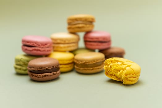 Colored tasty  macaroons over a green background.
