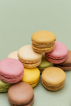 Colored tasty  macaroons over a green background.