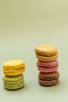 Colored tasty  macaroons over a green background.