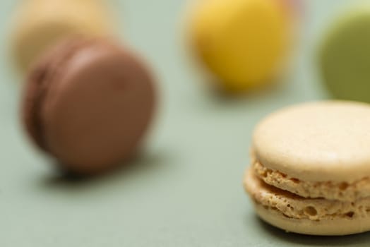 Colored tasty  macaroons over a green background.