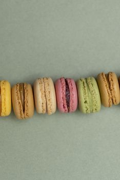 Colored tasty  macaroons over a green background.