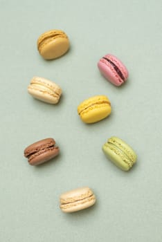 Colored tasty  macaroons over a green background.