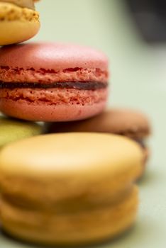 Colored tasty  macaroons over a green background.