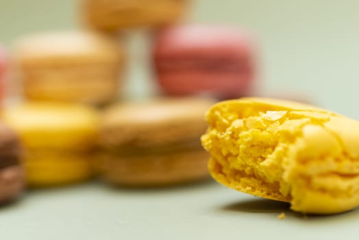 Colored tasty  macaroons over a green background.