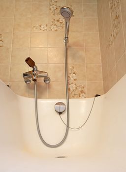 Old bathroom, brown tiled interior with bathtub