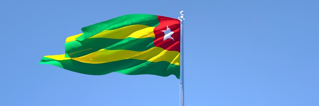 3D rendering of the national flag of Togo waving in the wind against a blue sky