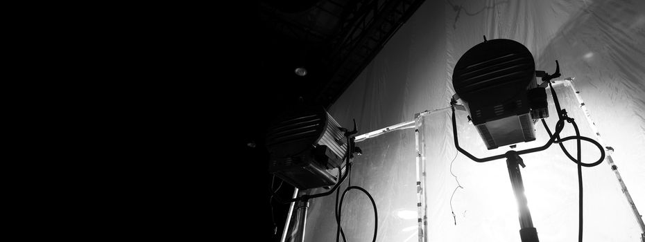 Black and white images of big studio continue LED light for video or film movie production on professional strong steel tripod and promt for shooting or set framing for director