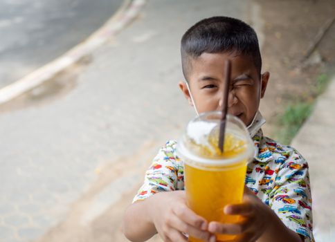 Boy holding a glass of water with a straw