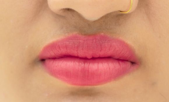 Beautiful gorgeous girl wearing gold earring with red pink lipstick on her sexy lips