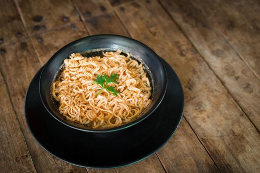 Instant noodles in a cup on the wooden floor, Asian meal, 3 minutes