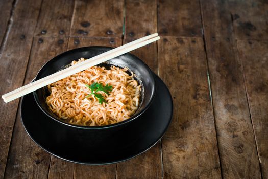 Instant noodles in a cup on the wooden floor, Asian meal, 3 minutes
