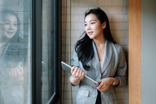 Portrait of smiling millennial businesswoman holding laptop computer looking at camera.