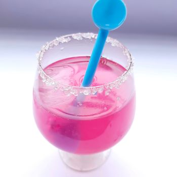 Colorful pink juice added with lemon juice and straw inside it plated beautifully in white background and good for immunity booster