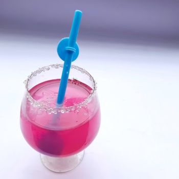 Colorful pink juice added with lemon juice and straw inside it plated beautifully in white background and good for immunity booster