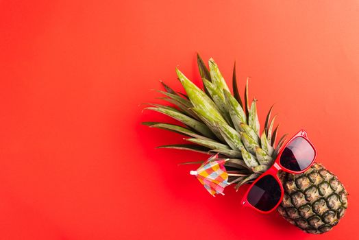 Celebrate Summer Pineapple Day Concept, Top view flat lay of funny pineapple wear red sunglasses, studio shot isolated on red background, Holiday summertime in tropical, minimal stylish fruit
