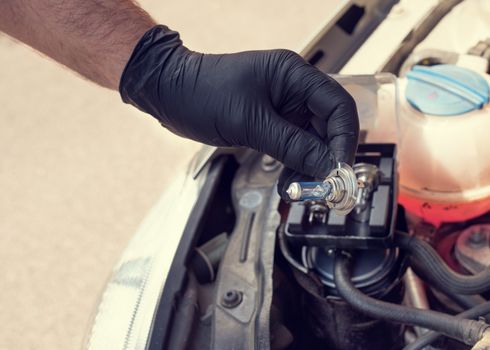 Hand of Man wearing black gloves repairing a car