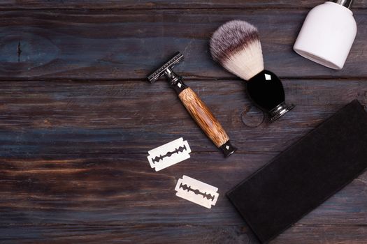 Razor, brush, perfume, balsam and shaving foam on a black background.