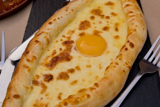 Georgian dish khachapuri with egg in the center. Soft focus. Closeup.