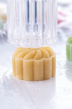 Young woman is making colorful snow skin moon cake, recipe of sweet snowy mooncake, traditional savory dessert for Mid-Autumn Festival, close up, lifestyle.