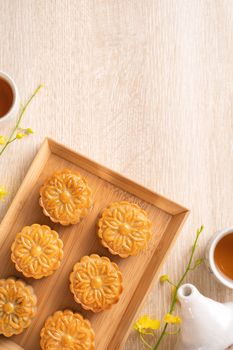 Mid-Autumn Festival holiday concept design of moon cake, mooncakes, tea set on bright wooden table with copy space, top view, flat lay, overhead shot