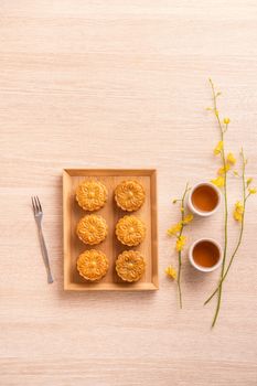 Mid-Autumn Festival holiday concept design of moon cake, mooncakes, tea set on bright wooden table with copy space, top view, flat lay, overhead shot