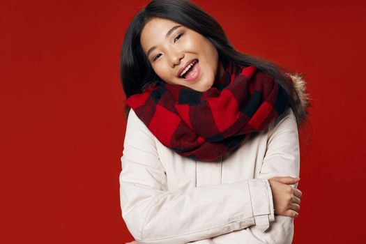A happy Asian woman smiles at the camera and hugs herself with her arms