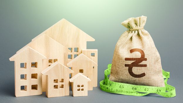 Residential houses and a ukrainian hryvnia money bag. Mortgage loan. Buying, fair price. Property real estate valuation. Calculation of construction and repair expenses. City municipal budget.