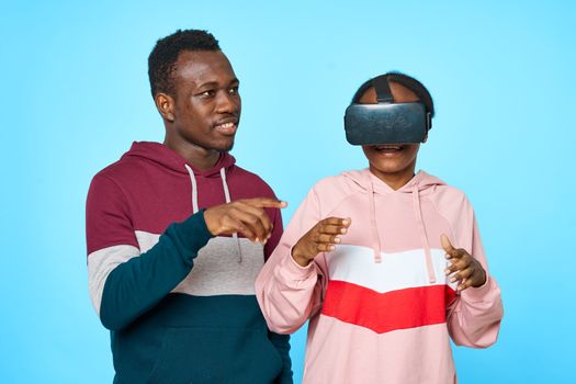 A woman of African appearance in 3D virtual reality glasses and a young guy