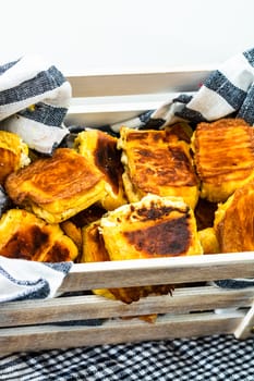 Freshly baked homemade ham and cheese puff pastry in a rustic crate.