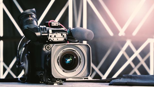 Blurry images of broadcast camera on the crane tripod for easy to shooting or recording and broadcasting content in studio production to on air tv or online internet live show.