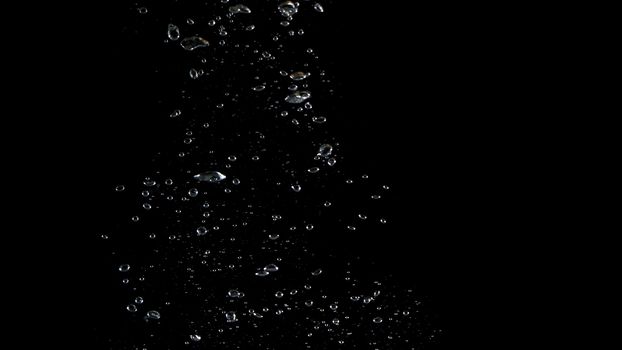 Extream close-up images of water bubbles or soda or liquid texture that splashing and floating up to surface like a explosion in black color background for refreshing carbonate drink concept.