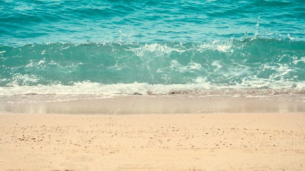 Clear light blue color sea water or liquid marine waving and splashing to light brown color sand beach on summer day in Pattaya Thailand and no people swimming because of hot weather.