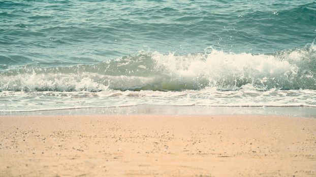 Clear light blue color sea water or liquid marine waving and splashing to light brown color sand beach on summer day in Pattaya Thailand and no people swimming because of hot weather.