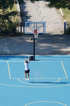 Varna, Bulgaria - August, 22, 2020: young man training with a ball on an outdoor basketball court