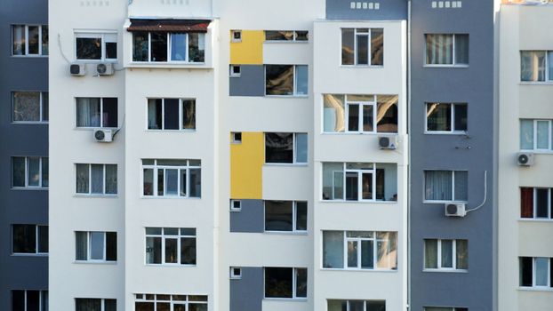 fragment of the facade of a multi-storey residential building for the background.