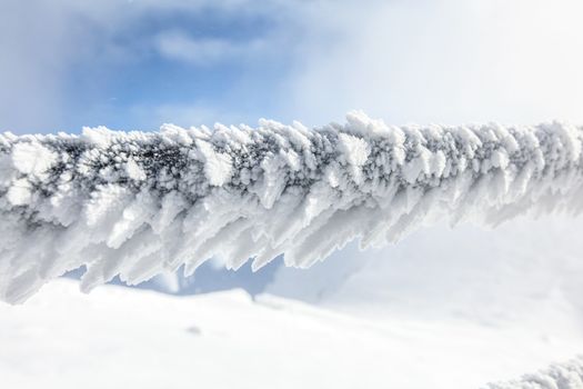 Detail on snow and ice covered stairs fence illustrating extreme cold in the winter. 