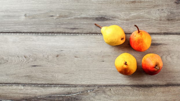 Top view of ripe pears, on gray wooden table.