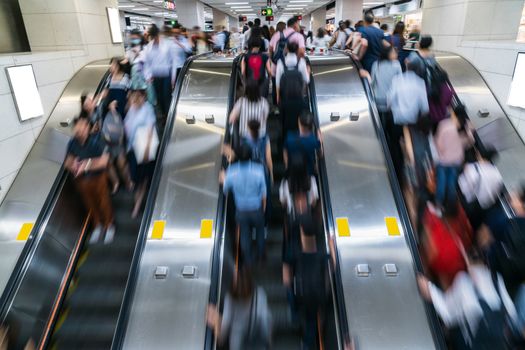 Crowd of Pedestrians Unrecognizable walking in escalator in rush hour morning before working time in subway transportation hub, Hong Kong, Central District, fast moving and business people concept