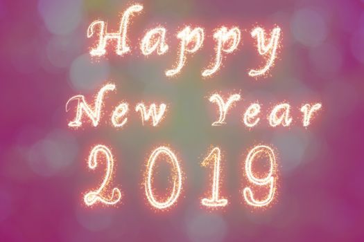 Happy new year 2019 written with Sparkle firework on fireworks with photo blurred bokeh background, celebration and greeting cards concept