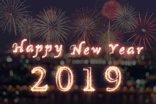 Happy new year 2019 written with Sparkle firework on fireworks with photo blurred of cityscape dark background, celebration and greeting cards concept