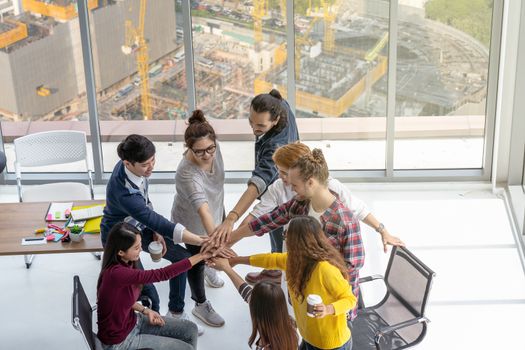 Top view scene of Asian and Multiethnic Business people standing and Hand coordination with happy action for teamwork in the modern workplace over under construction, business success concept