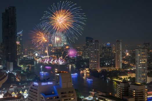 Multicolor Firework exploding over the Bangkok Cityscape river side for Celebration, Business architecture and celebration and happy new year and merry christmas concept