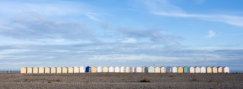 beach huts in cayeux s mer in french normandy under blue sky in early morning sunlight