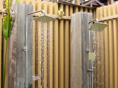 Water falling from the rain shower head of a swimming pool open area showers.