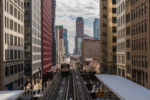 Elevated Train Tracks are running above the Railroad tracks between the building at the Loop line at Chicago, Illinois, USA