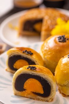 Tasty baked egg yolk pastry moon cake for Mid-Autumn Festival on bright cement table background. Chinese traditional food concept, close up, copy space.