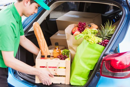 Asian delivery man grocery prepare service giving fresh vegetables food and fruit full in wooden basket on back car to send woman customer at door home after pandemic coronavirus, Back to new normal