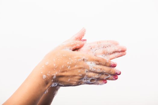 Closeup young Asian woman washing hands by soap for cleanliness and prevent germs coronavirus, studio shot isolated on white background, Healthcare medical COVID-19 virus concept